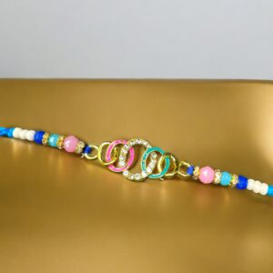 Colorful multicolor Rakhi with interlinked rings and beaded strap on golden background – ideal for Raksha Bandhan 2025