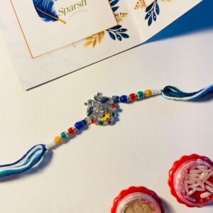 Elegant Peacock Rakhi with multicolor beads, blue and green thread, festive Raksha Bandhan greeting card and roli chawal
