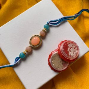 Elegant peach and aqua Rakhi with gemstone beads on eco-friendly packaging